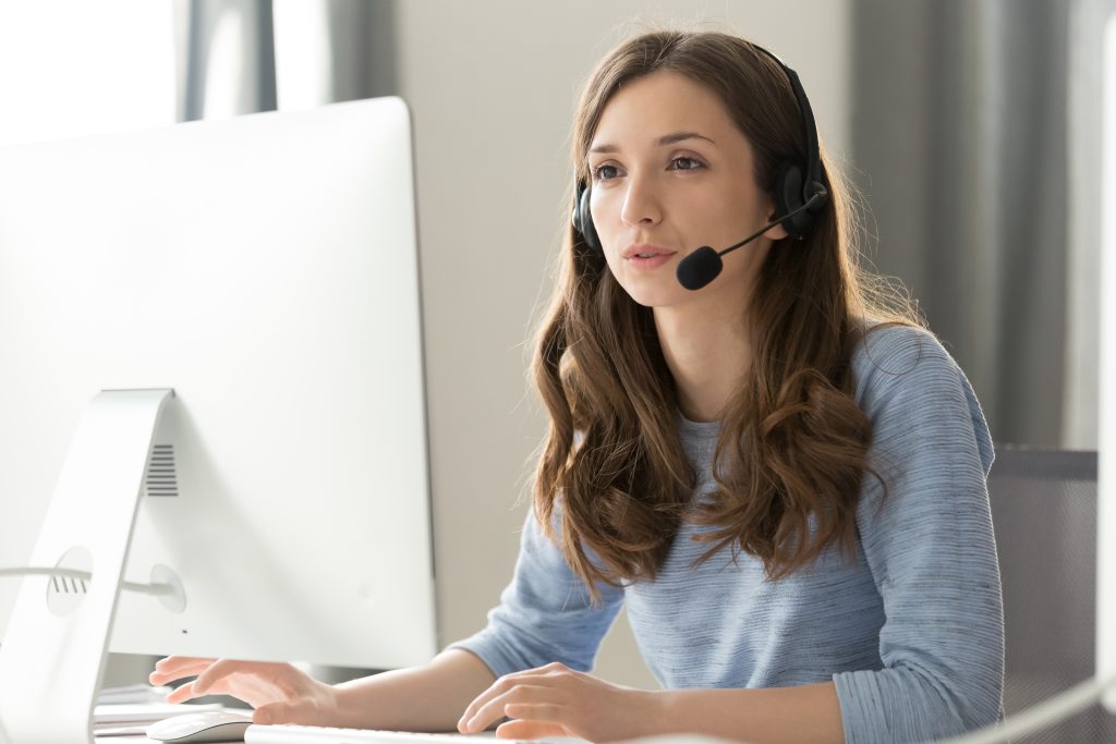 RenoAssistance Renovation Advisor answering a call in front of a computer