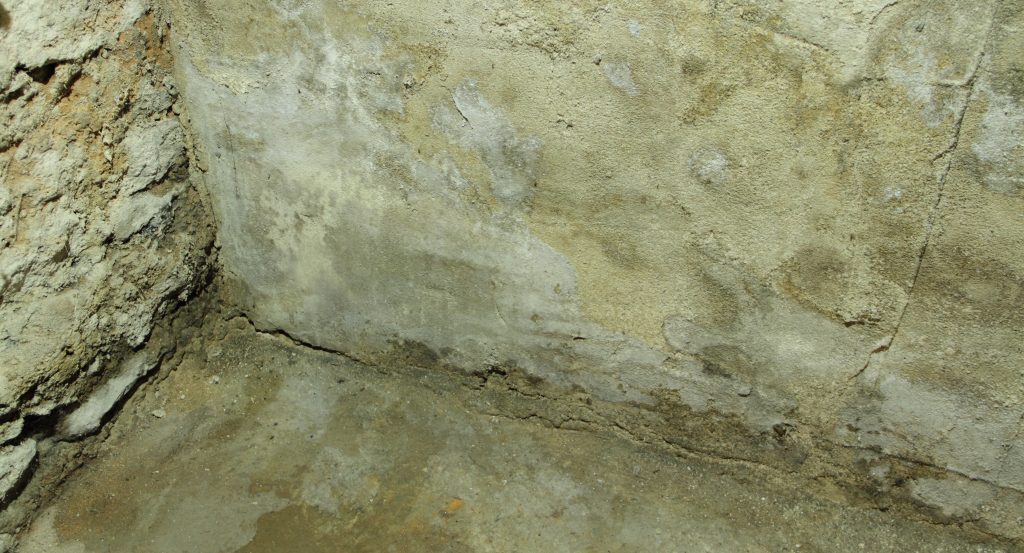 Dans un sous-sol humide, fissures sur murs de béton