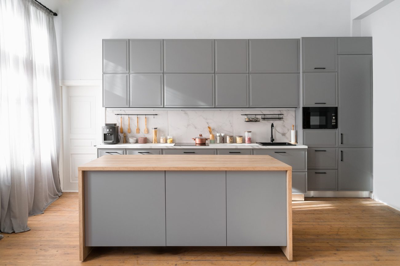 Modern kitchen with grey furniture and cascade island on wooden floor, cooking utensils and jars with food