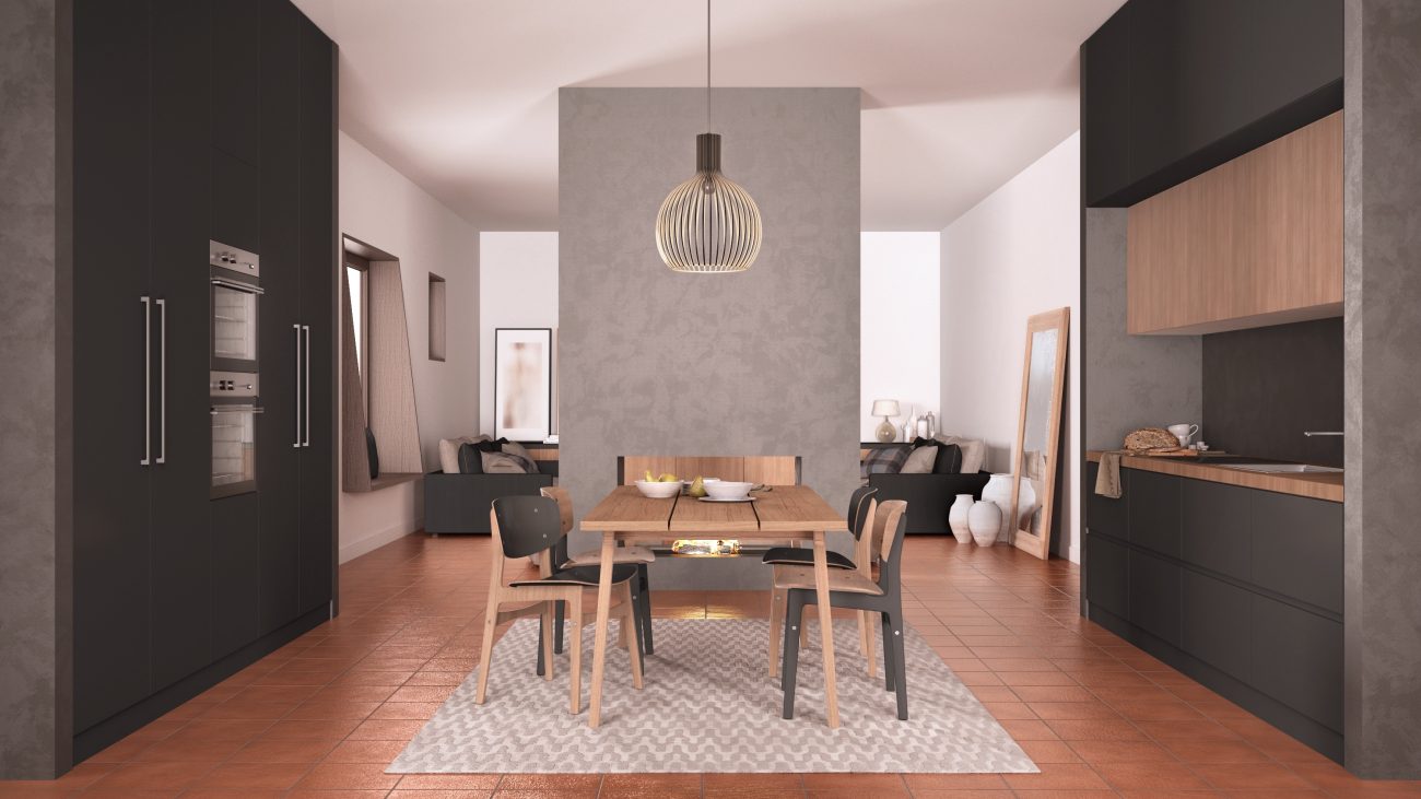 Dark grey, black and wooden kitchen with terracotta tile floors, dining table and chairs, concrete wall