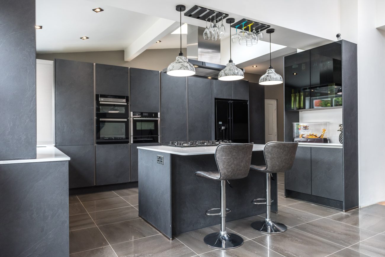 In a modern dark grey kitchen, skylight and slate flooring