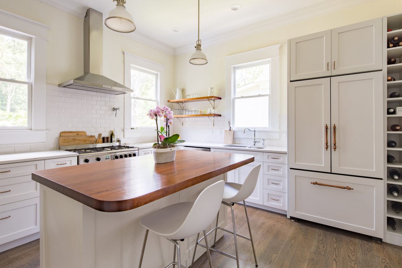 Modern kitchen with island, wood countertop with rounded corners, white cabinets, open shelves