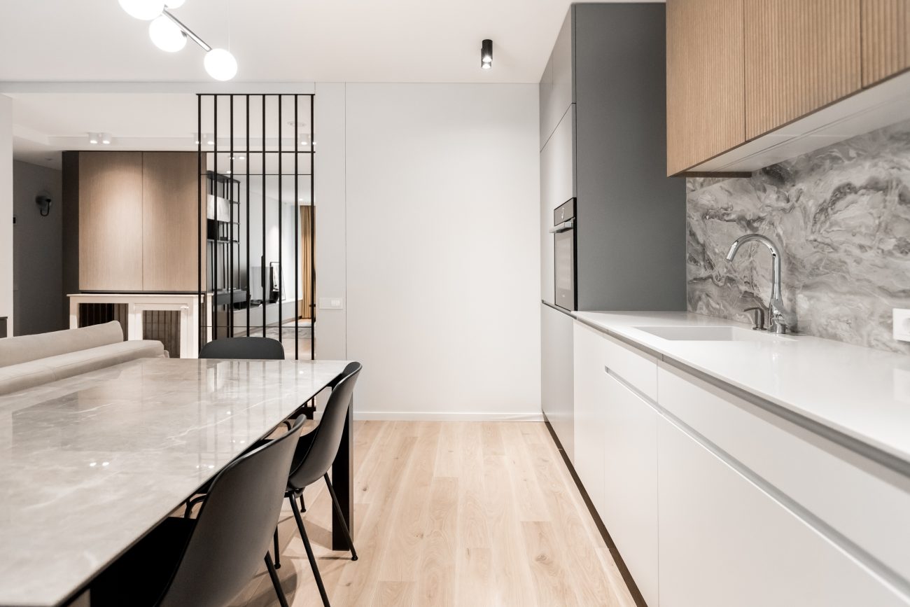 Long marble dining table in front of a kitchen counter, black claustra