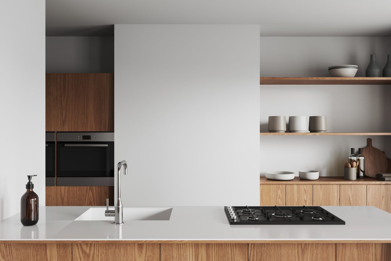 Modern kitchen with white walls, wooden island with built-in sink and cooker, and open shelves for dishes