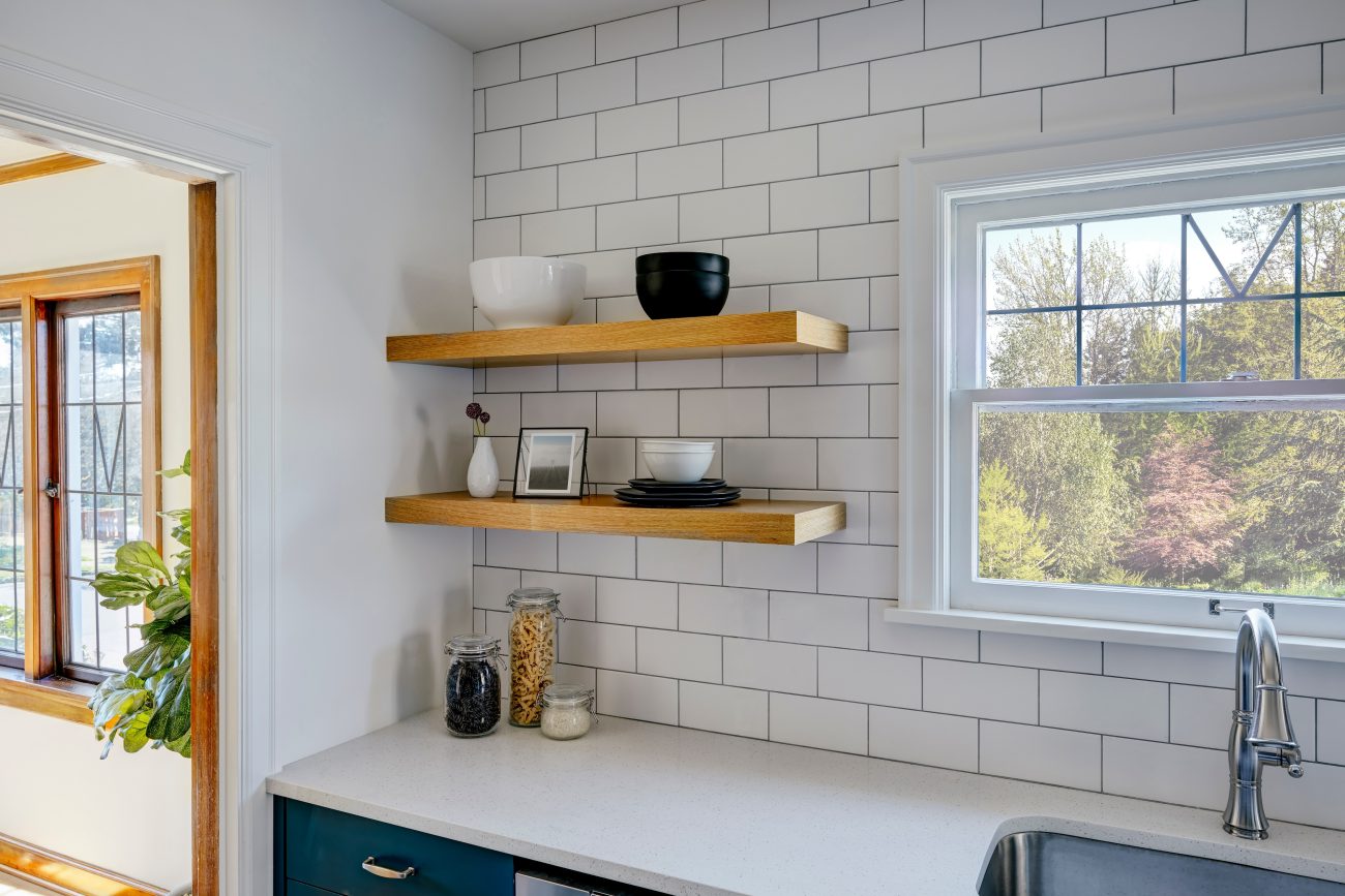 Subway tiles in a modern kitchen with checkered windows and two wooden shelves