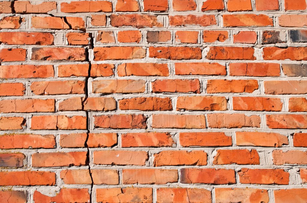 Red brick wall with vertical crack 