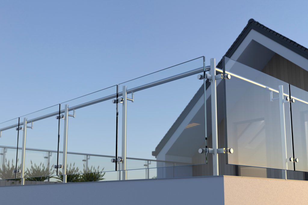 Balustrade entourant la terrasse d’une maison, avec garde-corps en verre trempé et pieux en acier inoxydable