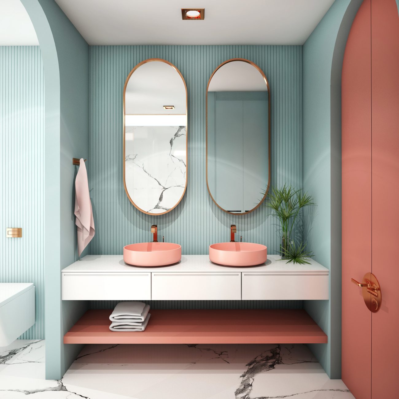 In a bathroom with arched walls, an alcove with fluted texture painted aquamarine blue, white vanity with two peach-colored round basins, matching floating shelf and double closet doors. Two oval mirrors, a green plant on the counter