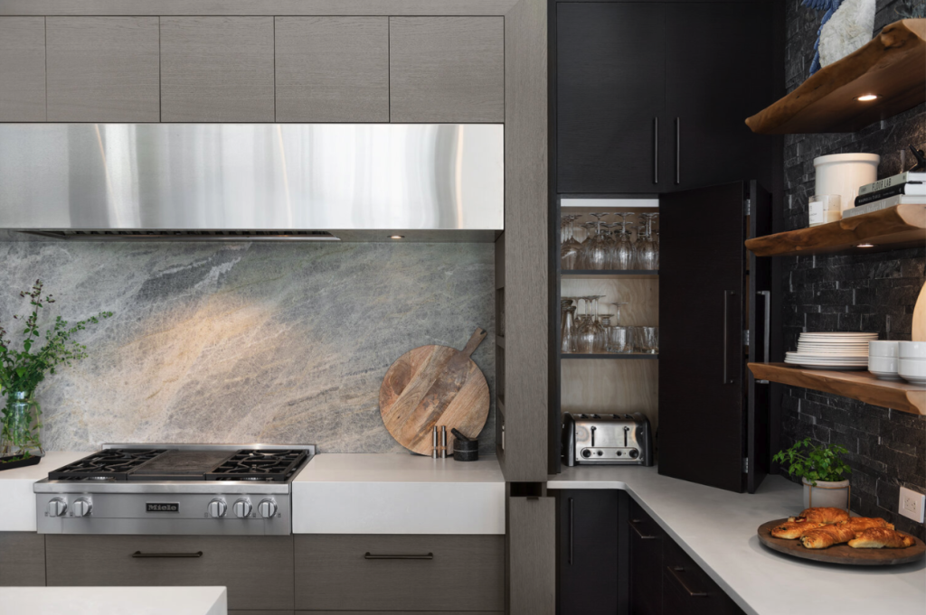 Stainless steel hood and oven in a gray and black kitchen