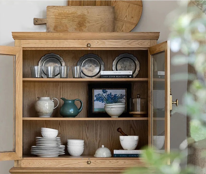 Wooden glass cabinet with pots, plates, frames, glasses and books