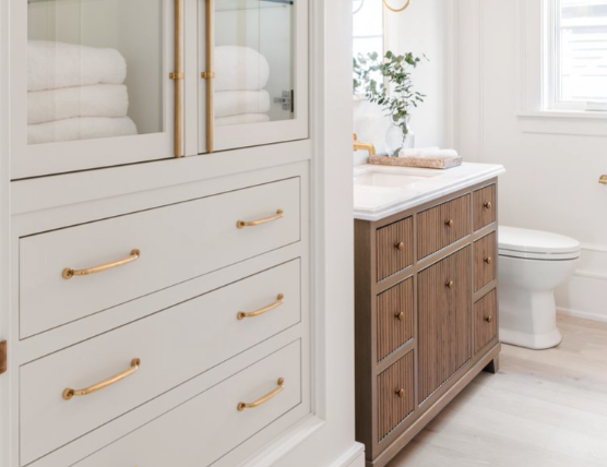 Bathroom shelf with golden handles and accessories on shelves 