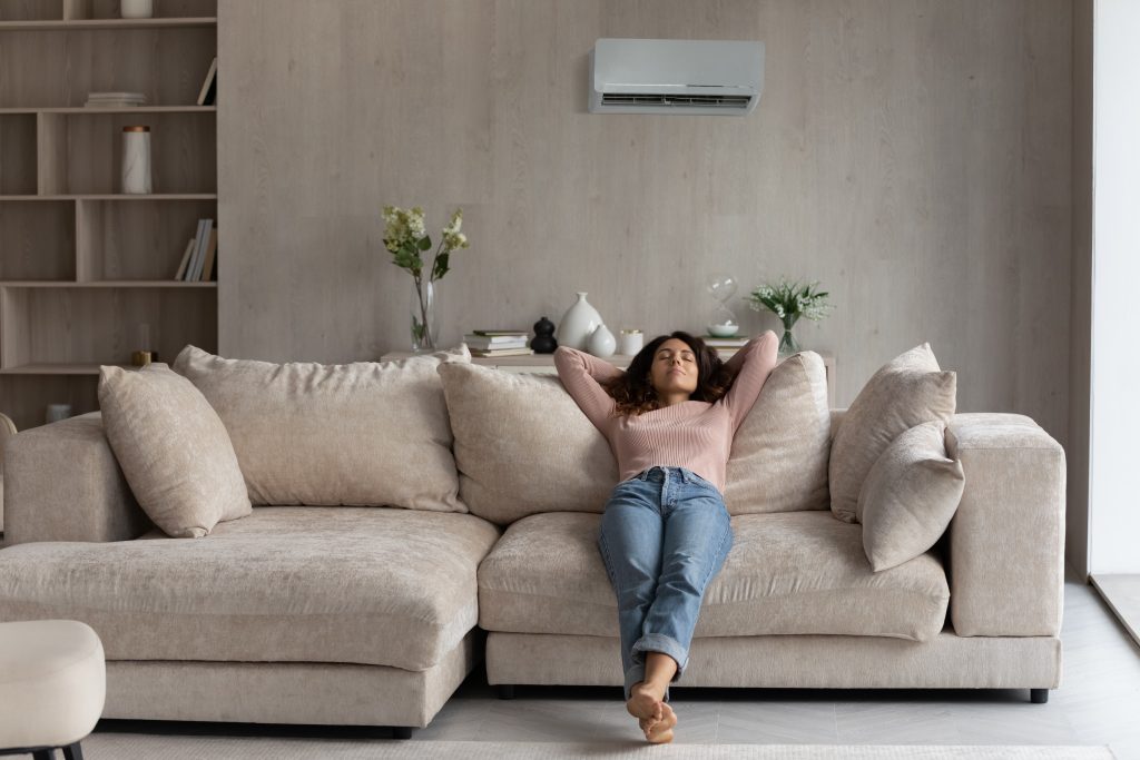 Woman relaxing in a living room, sitting comfortably on a modular sofa.