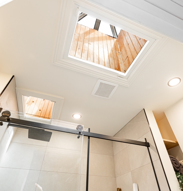 Contemporary white bathroom with skylight view.