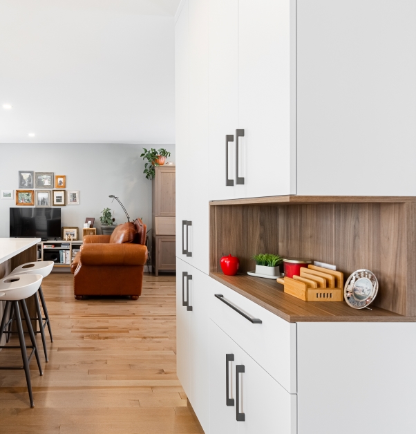 White modern kitchen with white cabinets, hardwood floor