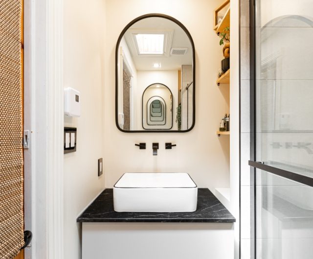 Salle de bain contemporaine blanche avec vue sur miroir et vasque blanche.