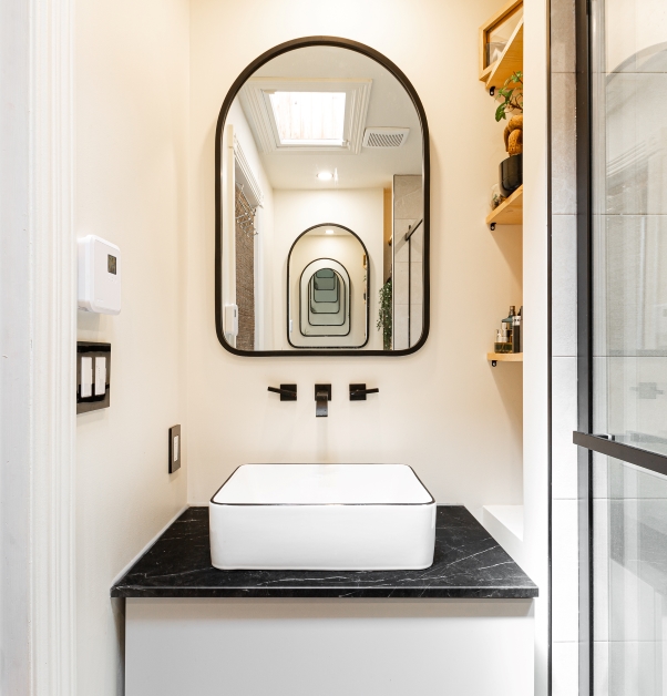 Salle de bain contemporaine blanche avec vue sur miroir et meuble-lavabo.