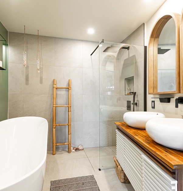 Salle de bain contemporaine blanche avec vue sur meuble-lavabo double, douche italienne et bain autoportant.