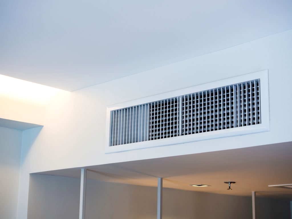 Grille de ventilation située près du plafond dans une chambre