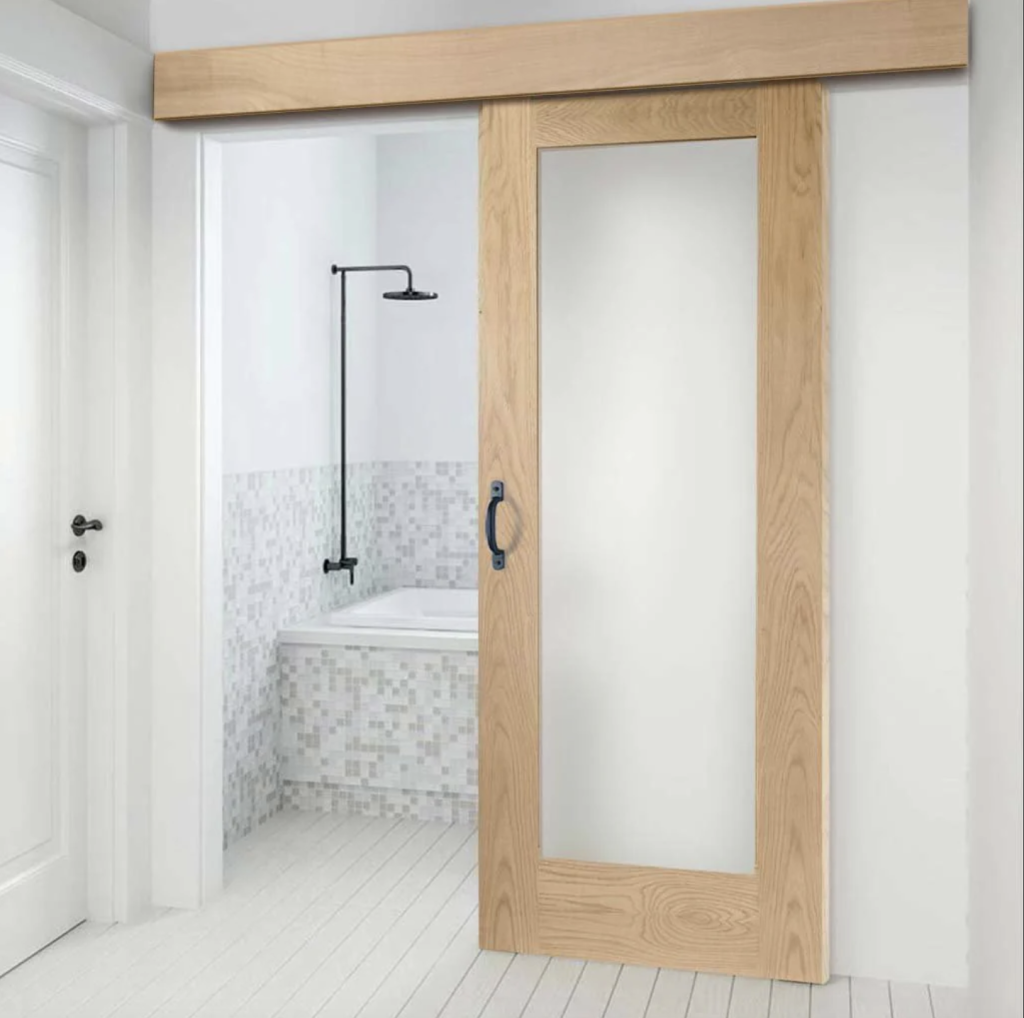 Sliding glass door with a natural wood frame, opening onto a bathroom with a bathtub and walls covered in small grey and white tiles