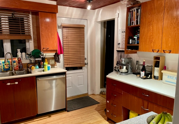 Classic brown kitchen with view of brown wood cabinets, wood floor and side door