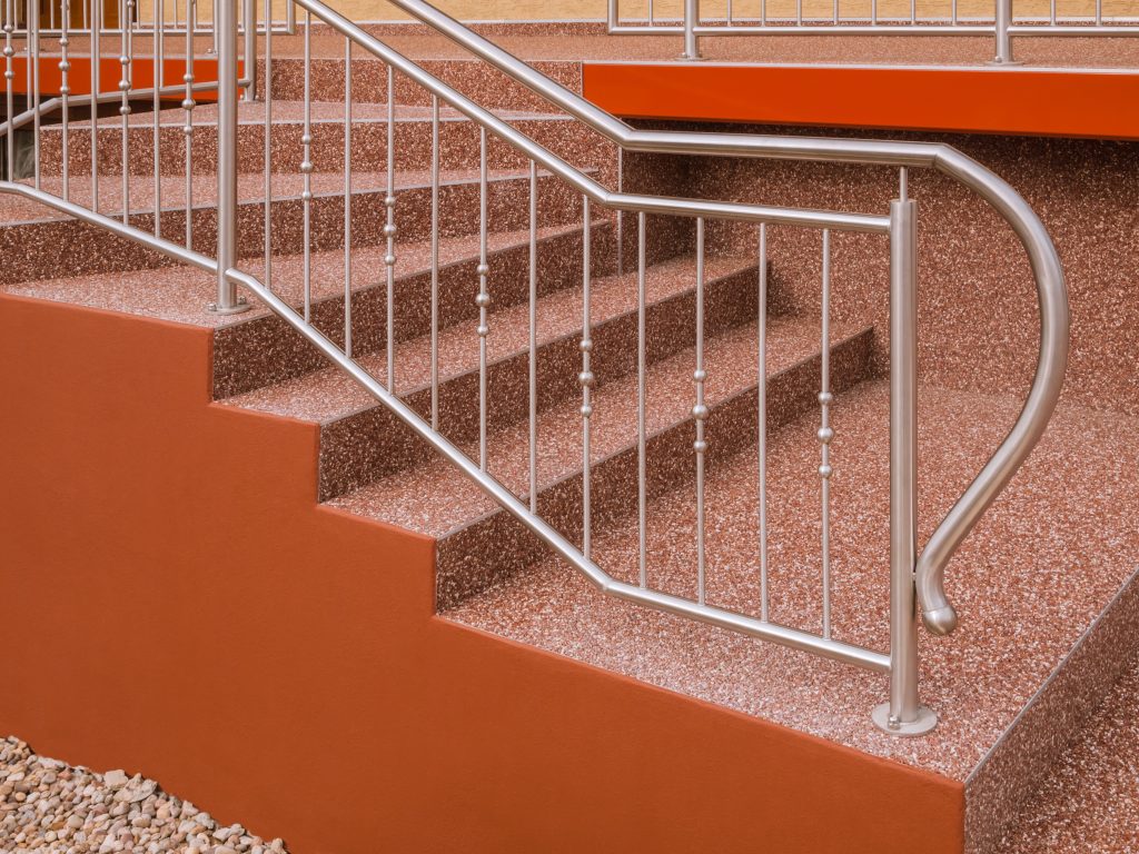 Red-brown epoxy staircase with silver railing