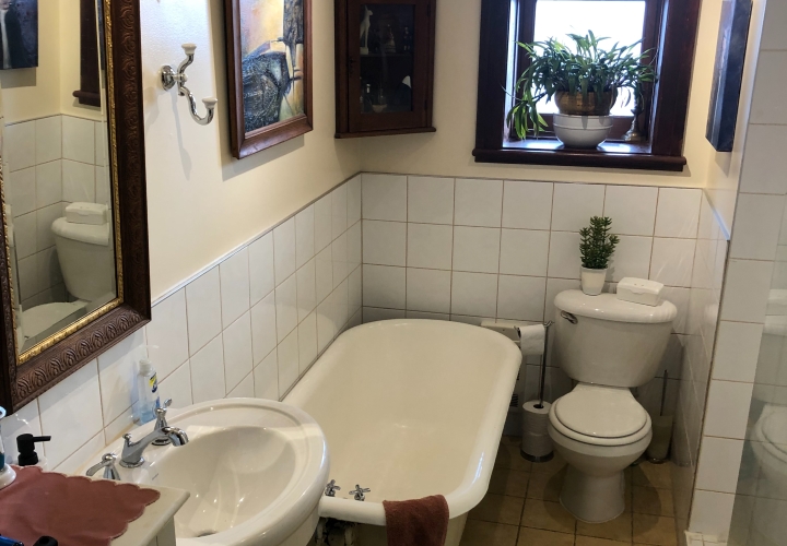 Small classic beige bathroom with white ceramic wall and brownish-red wood decorations