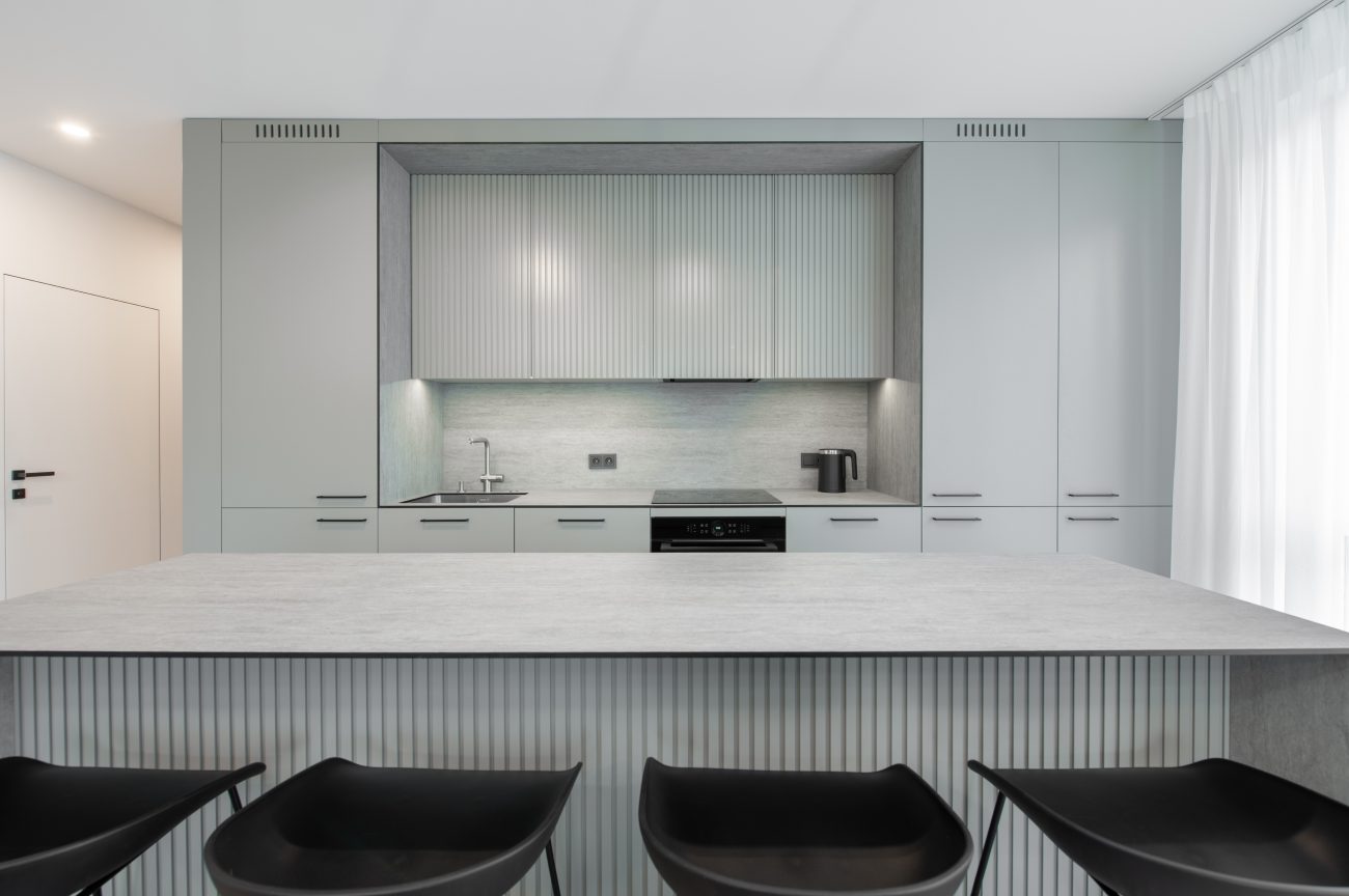 Minimalist Scandinavian gray kitchen with grooved island