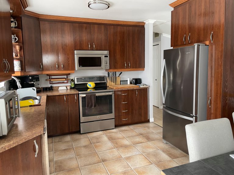 Old kitchen with brown cabinets and gray handles