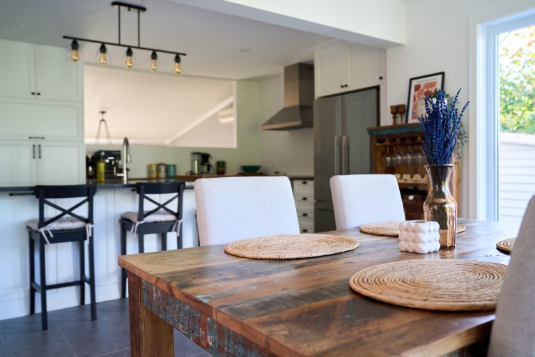 Black counter stools with gray cushions in front of a kitchen island