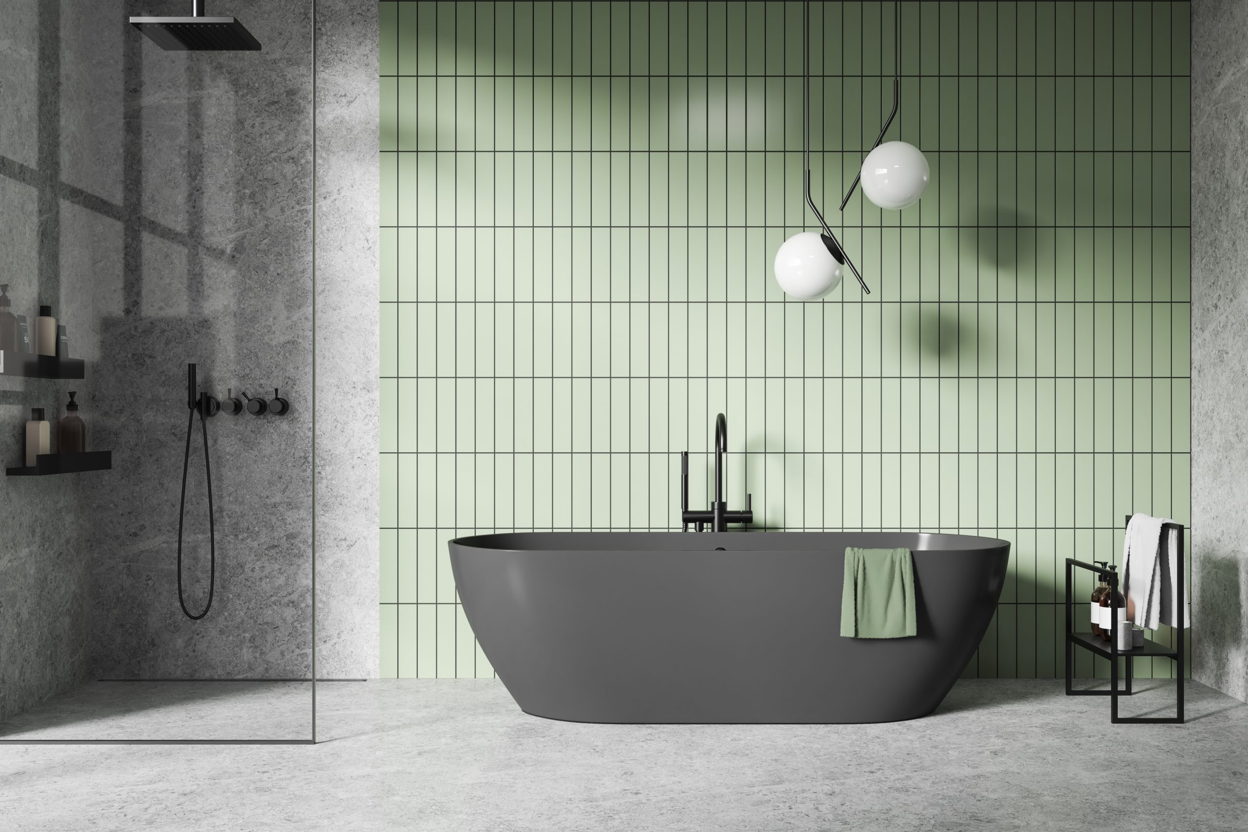 Bathroom with mouse grey marble tiles on the floor and walk-in shower wall, anthracite grey freestanding bathtub, accent wall with wasabi green ceramic tiles, contemporary light fixture with two frosted glass globes